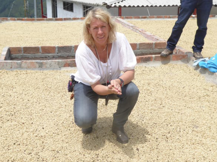 Kvinna sitter på marken och håller i råkaffe