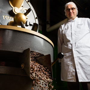 Zoegas kaffebönor i en maskin med en professionell person bredvid