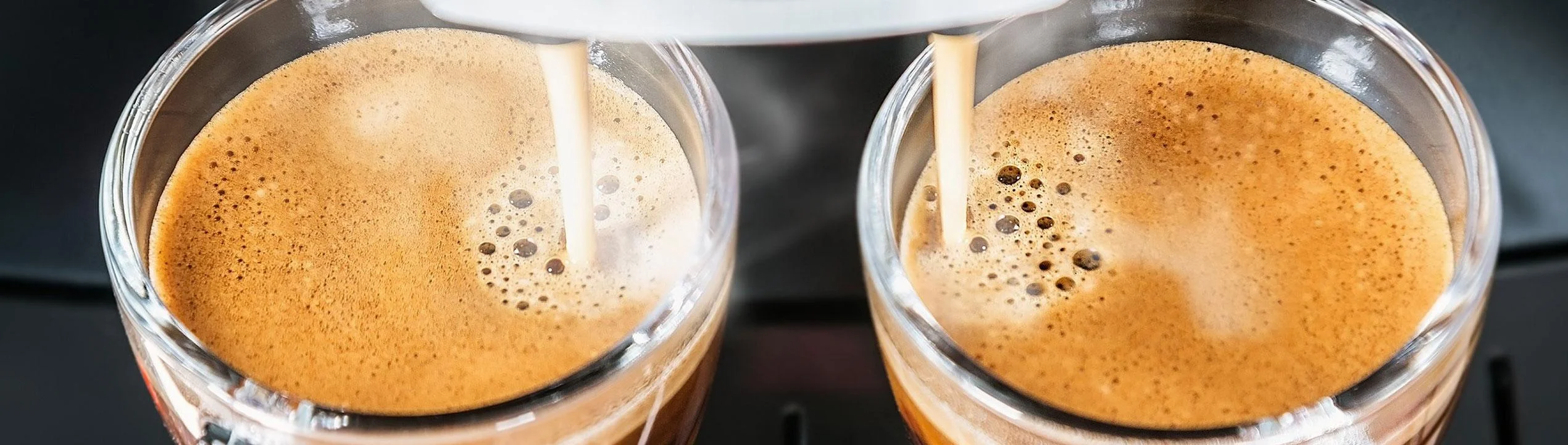 Två espresso rinner ner i koppar