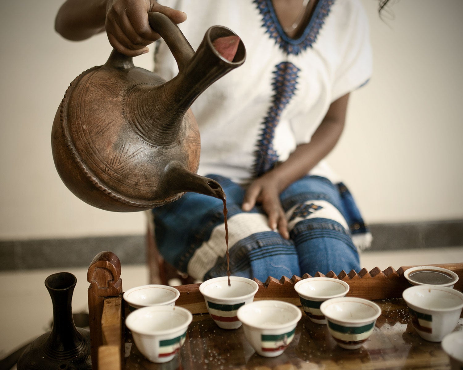 Kvinna häller upp kaffe i kaffekoppar