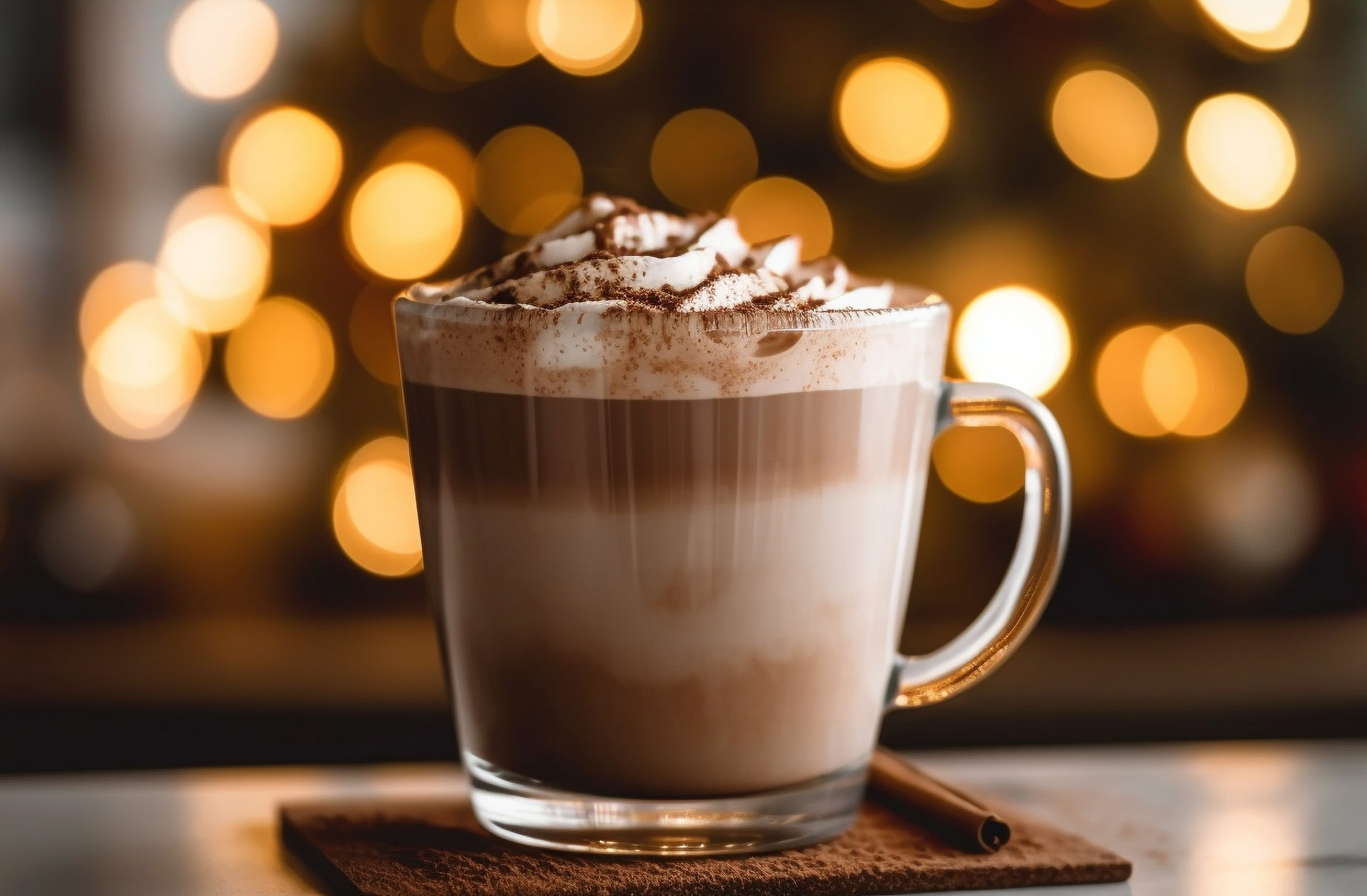 Varma choklad serverad i en glasburk med skum och chokladpulver ovanpå