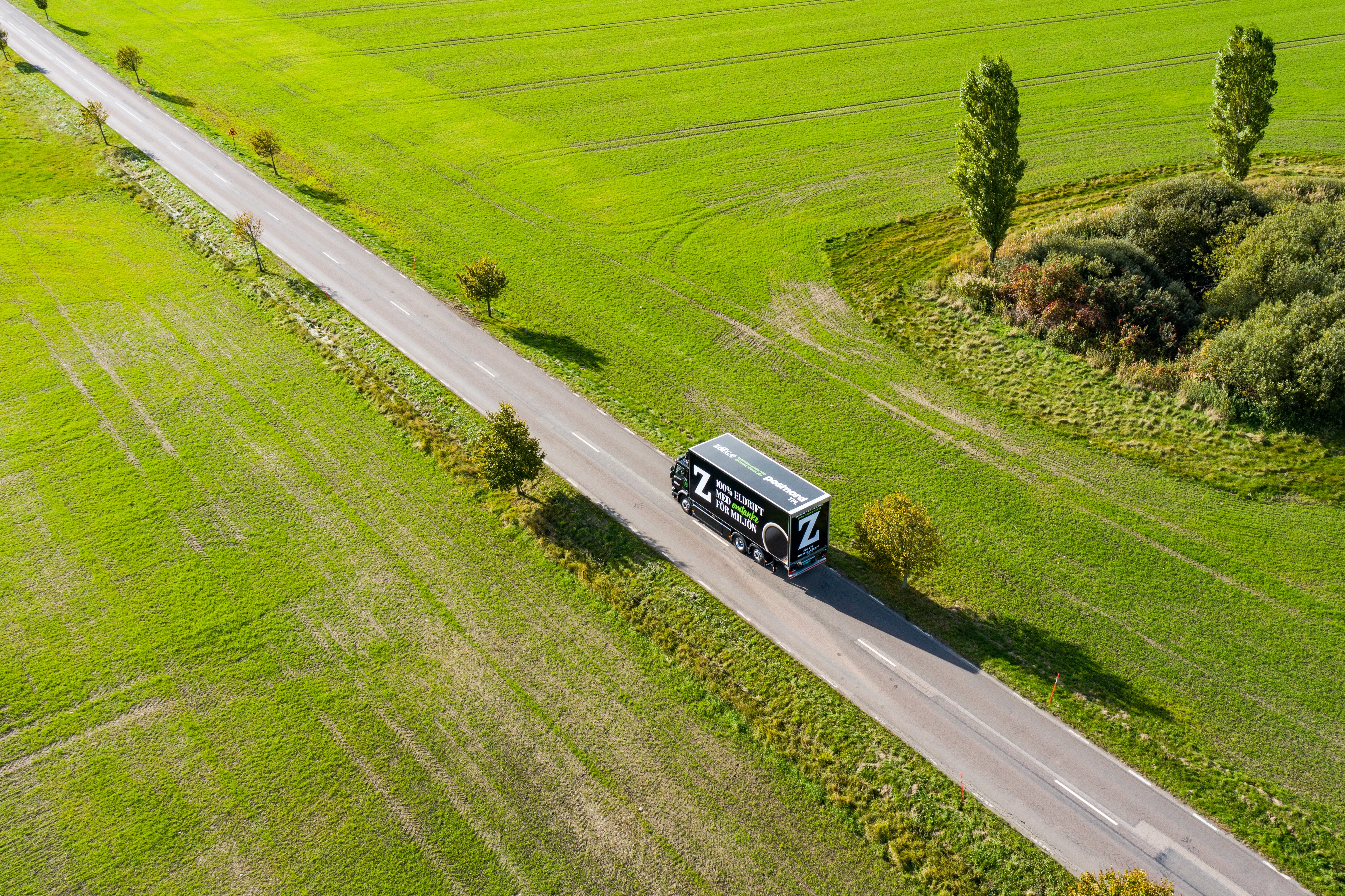 Zoégas transportlastbil på en väg omgiven av grönområden.