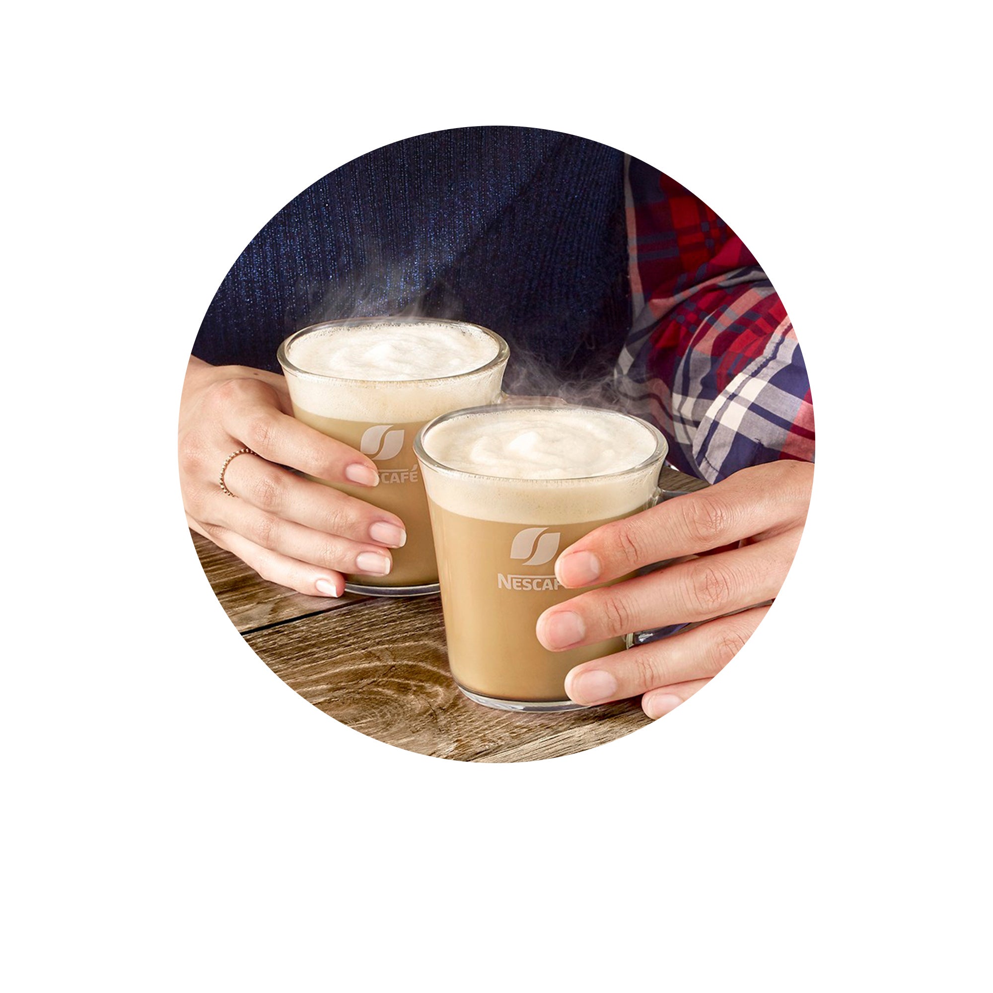 Varm dryck i en Nescafé-kopp på ett träbord med händer som håller i dryckerna