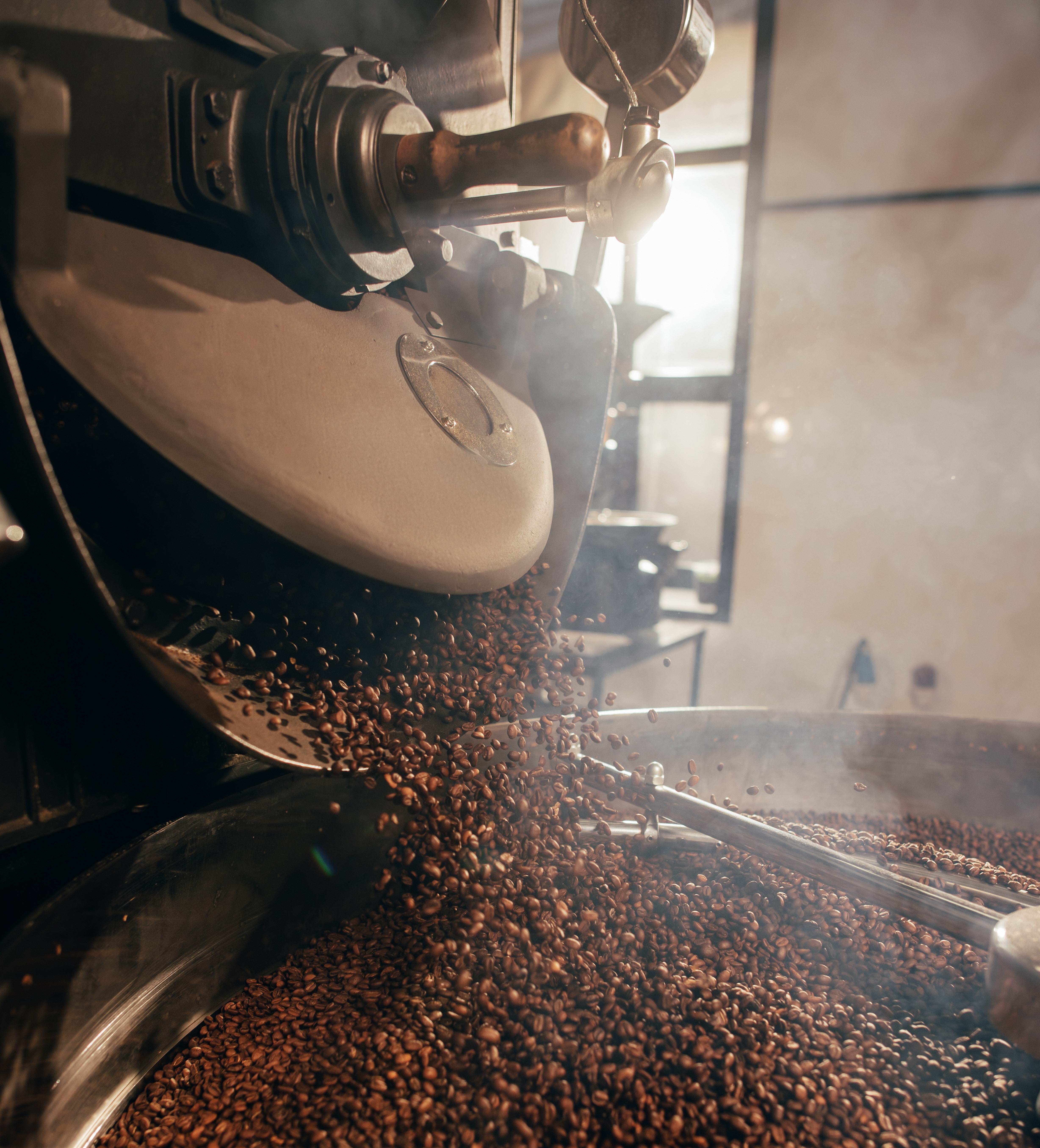 Kaffebönor som malas i en industriell kaffekvarn