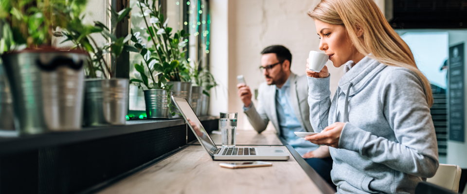 Medarbejdere arbejder og nyder en kop kaffe på arbejdet