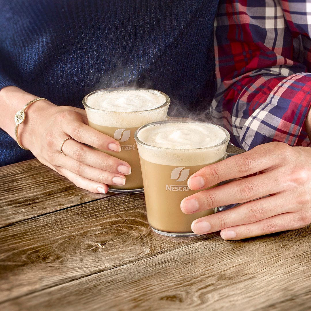 To latte i gjennomsiktige glass med Nescafé-logoen