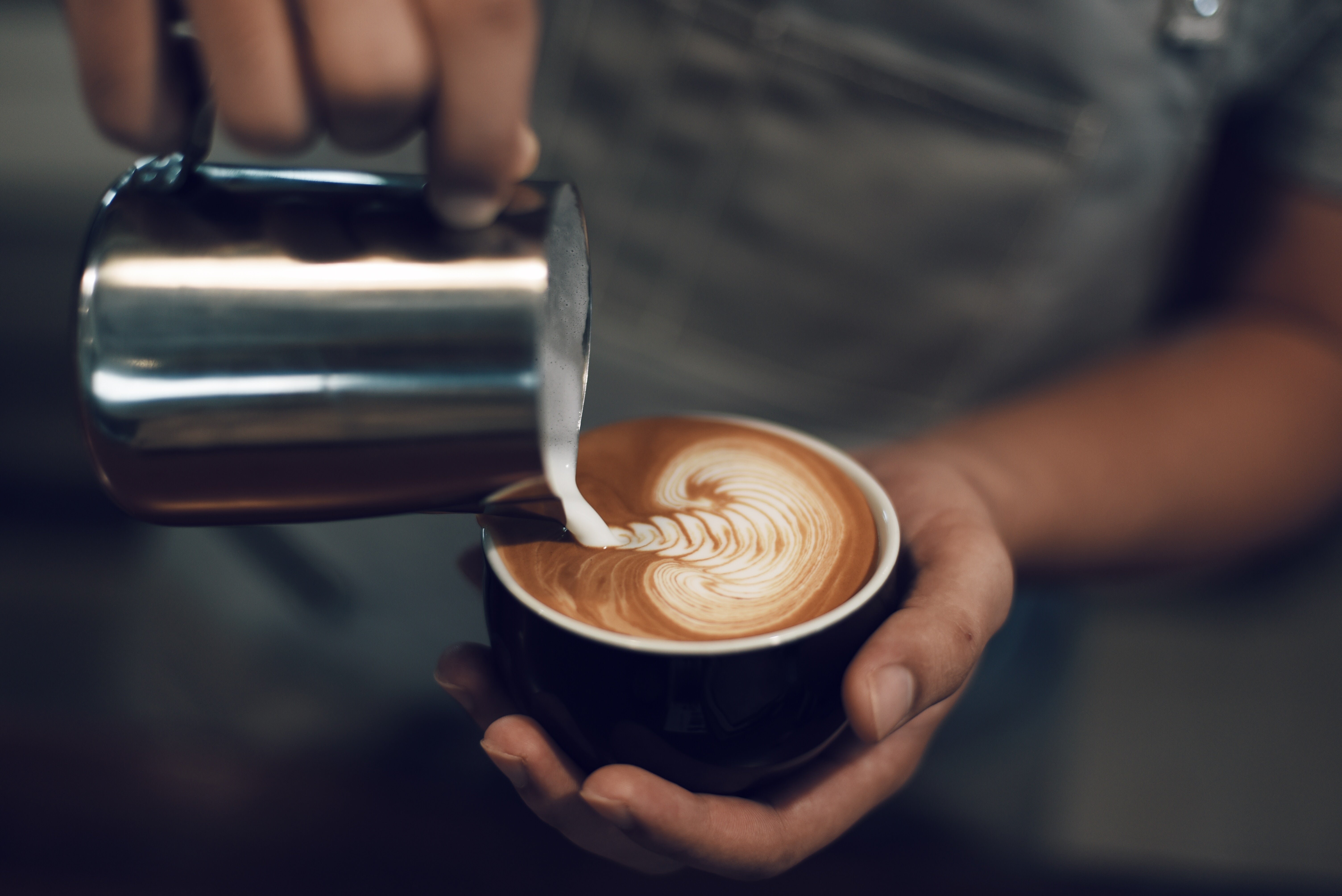 Cappuccino tarjoillaan kahvimukissa.