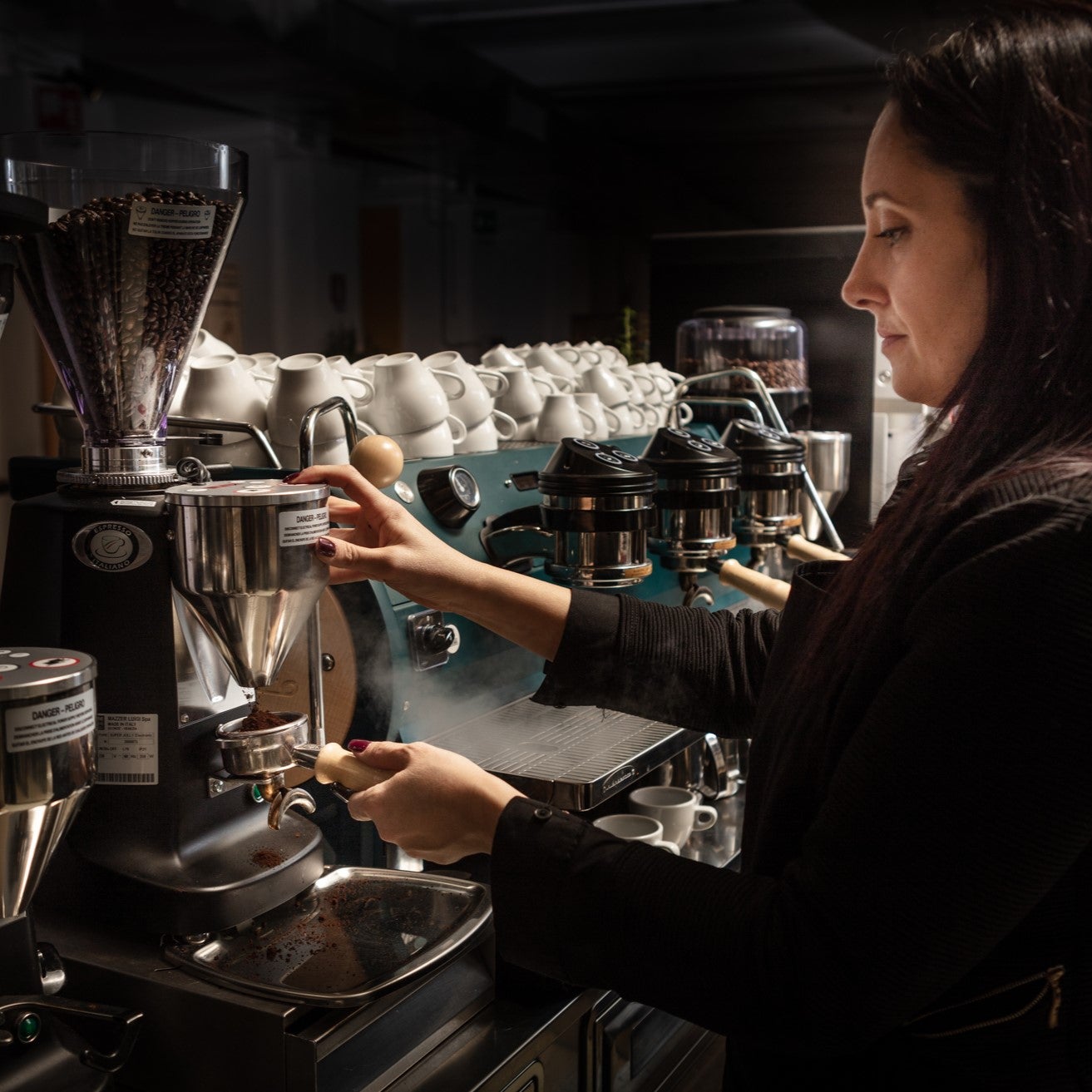 kvinna serverar Zoegas-kaffe från en industriell kaffemaskin