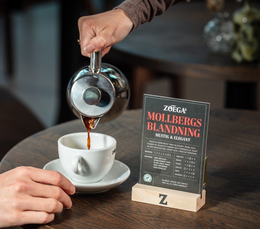 Person som serverar kaffe i en kanna.