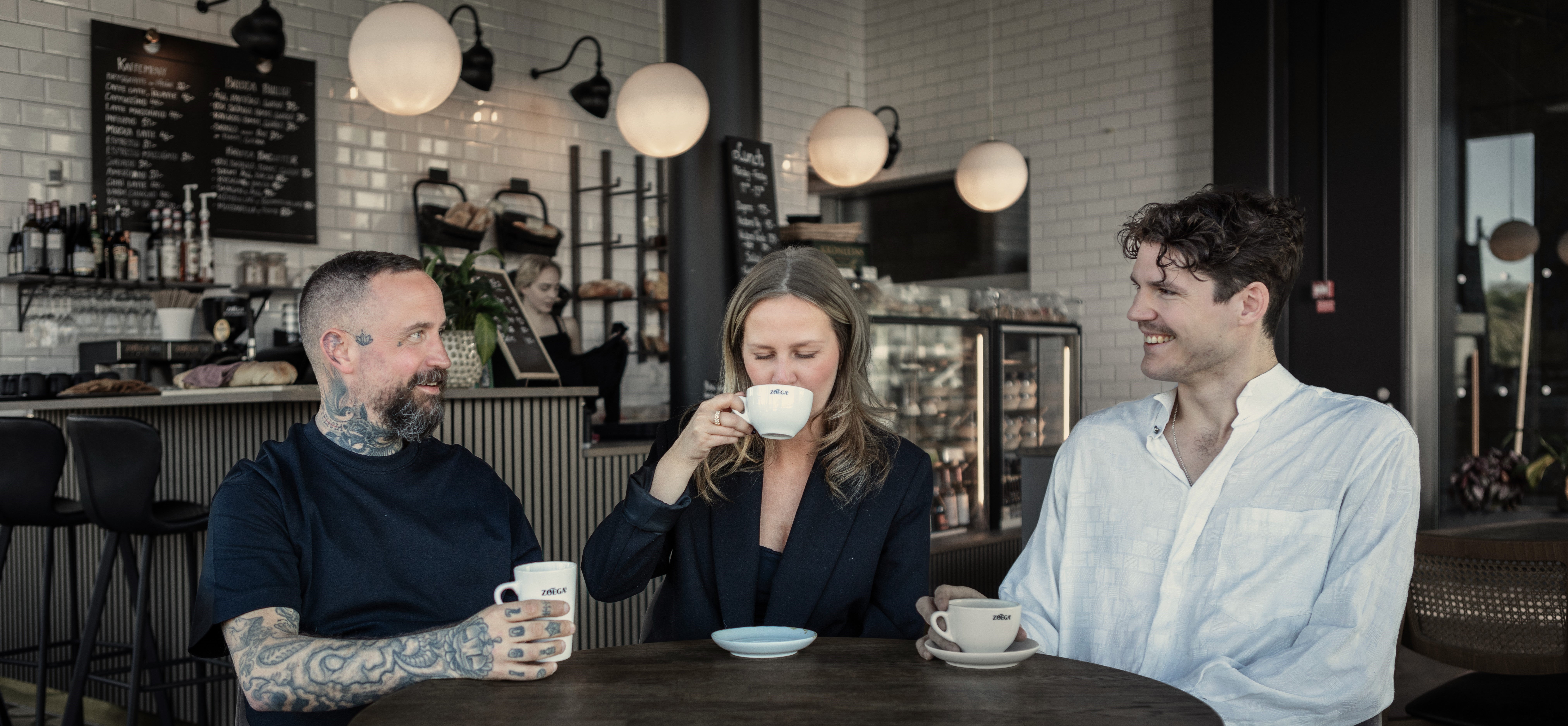 Tre gäster dricker Zoégas kaffe på ett café
