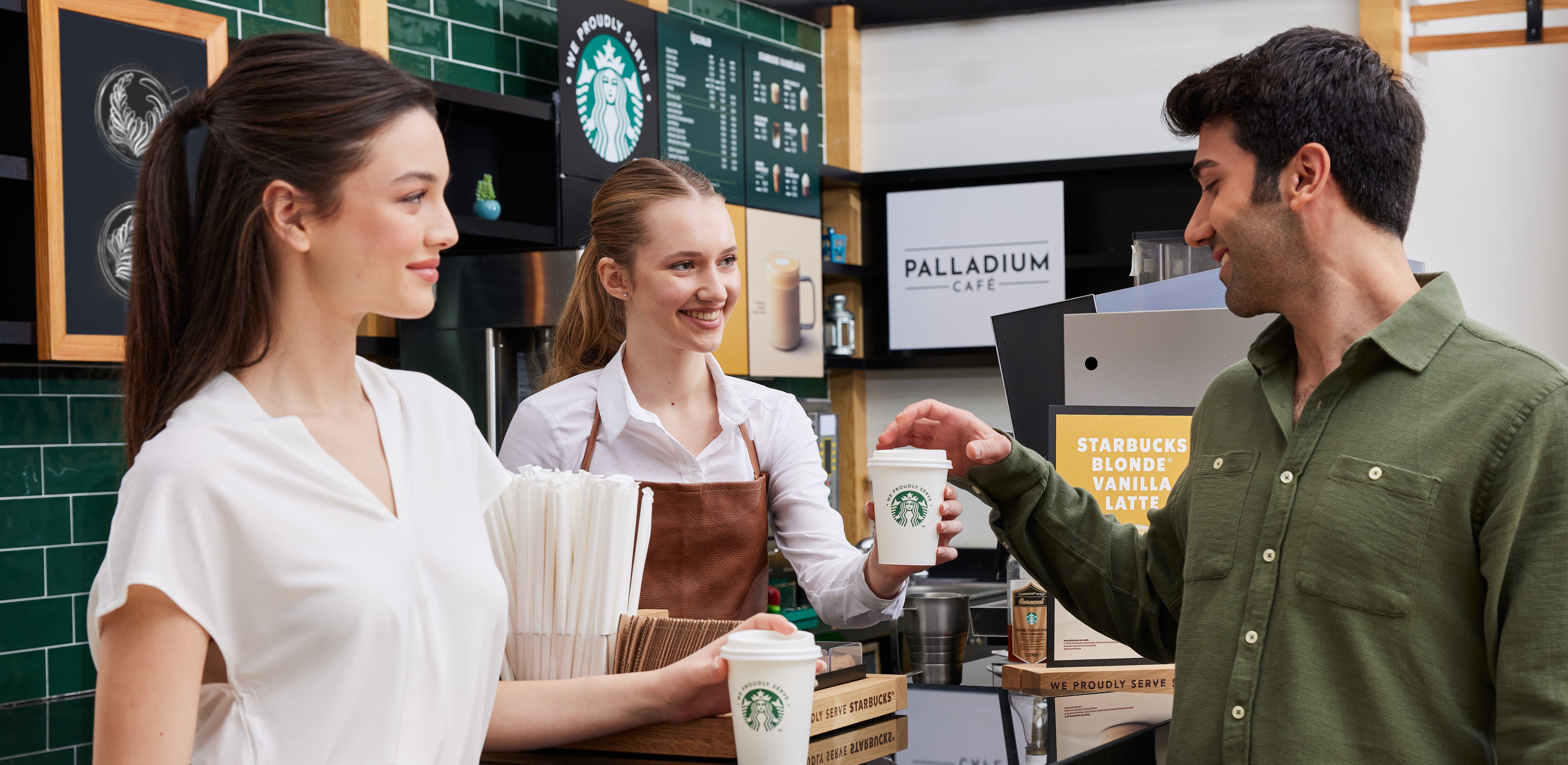 To gjester får servert kaffe på Starbucks