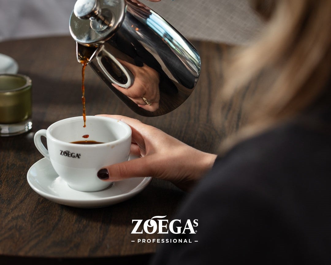 Servitris häller upp kaffe i Zoégas mugg