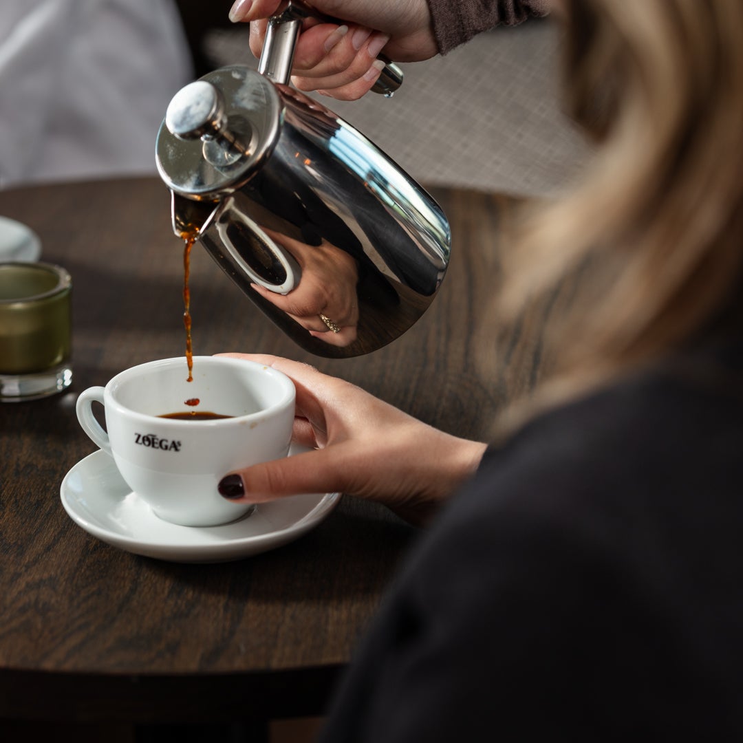 Man greppar en kopp Zoégas kaffe