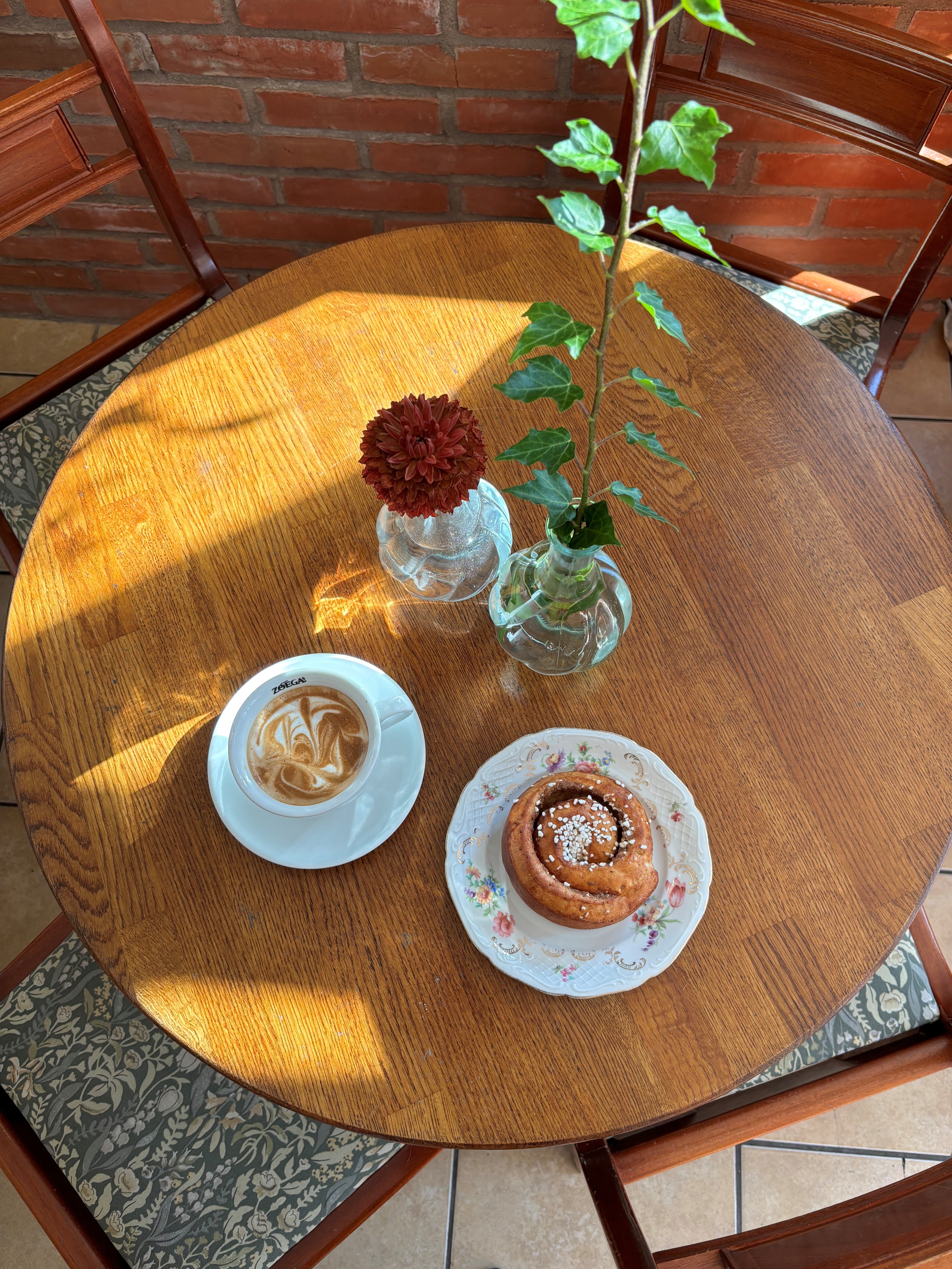 Ett bord med kanelbulle och cortado