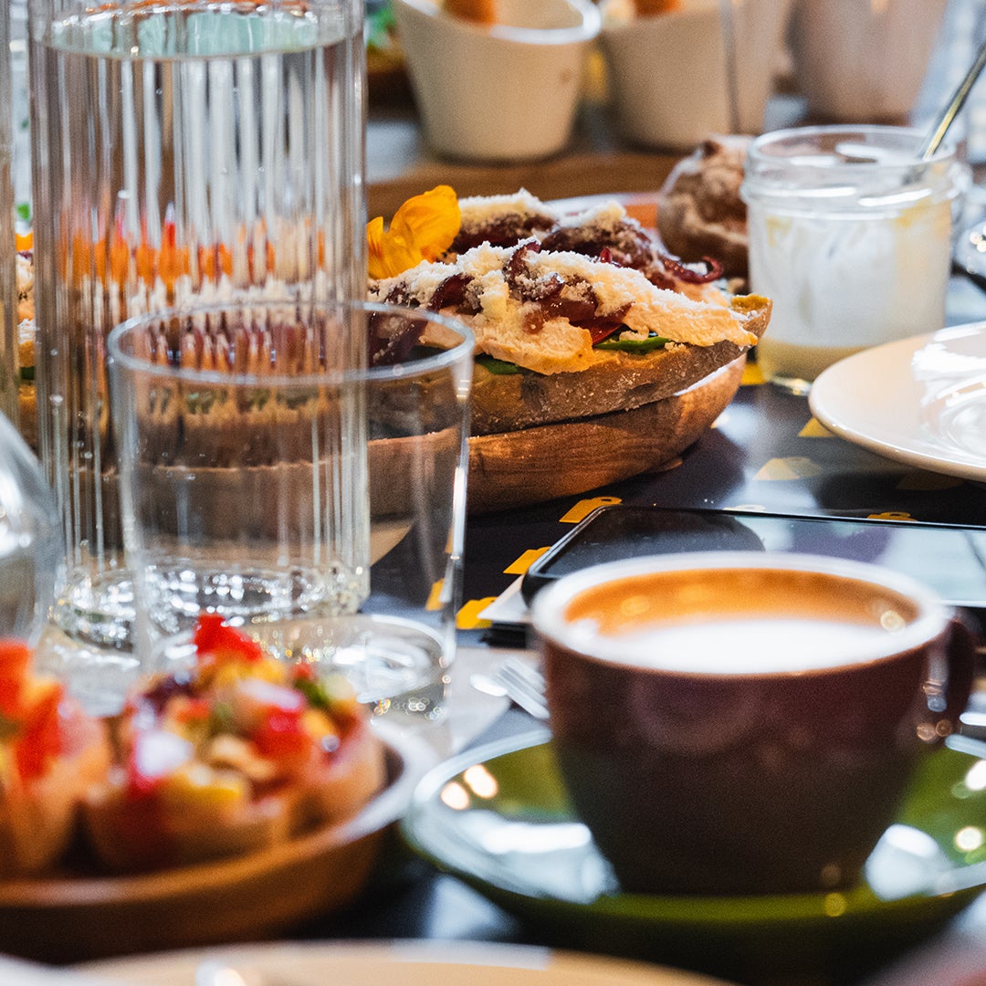 bord fyllt med kaffe, cappuccino och sötsaker