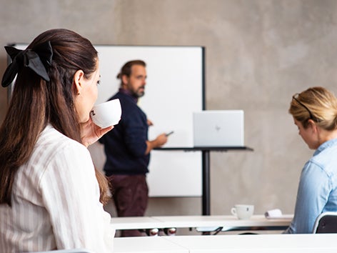 Två flickor dricker kaffe medan de förbereder sig för en lektion