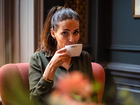 Tjej som sitter och dricker kaffe.