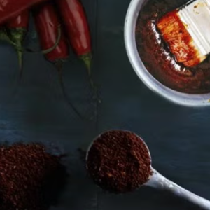 Malda kaffebönor i en skål med chili i bakgrunden