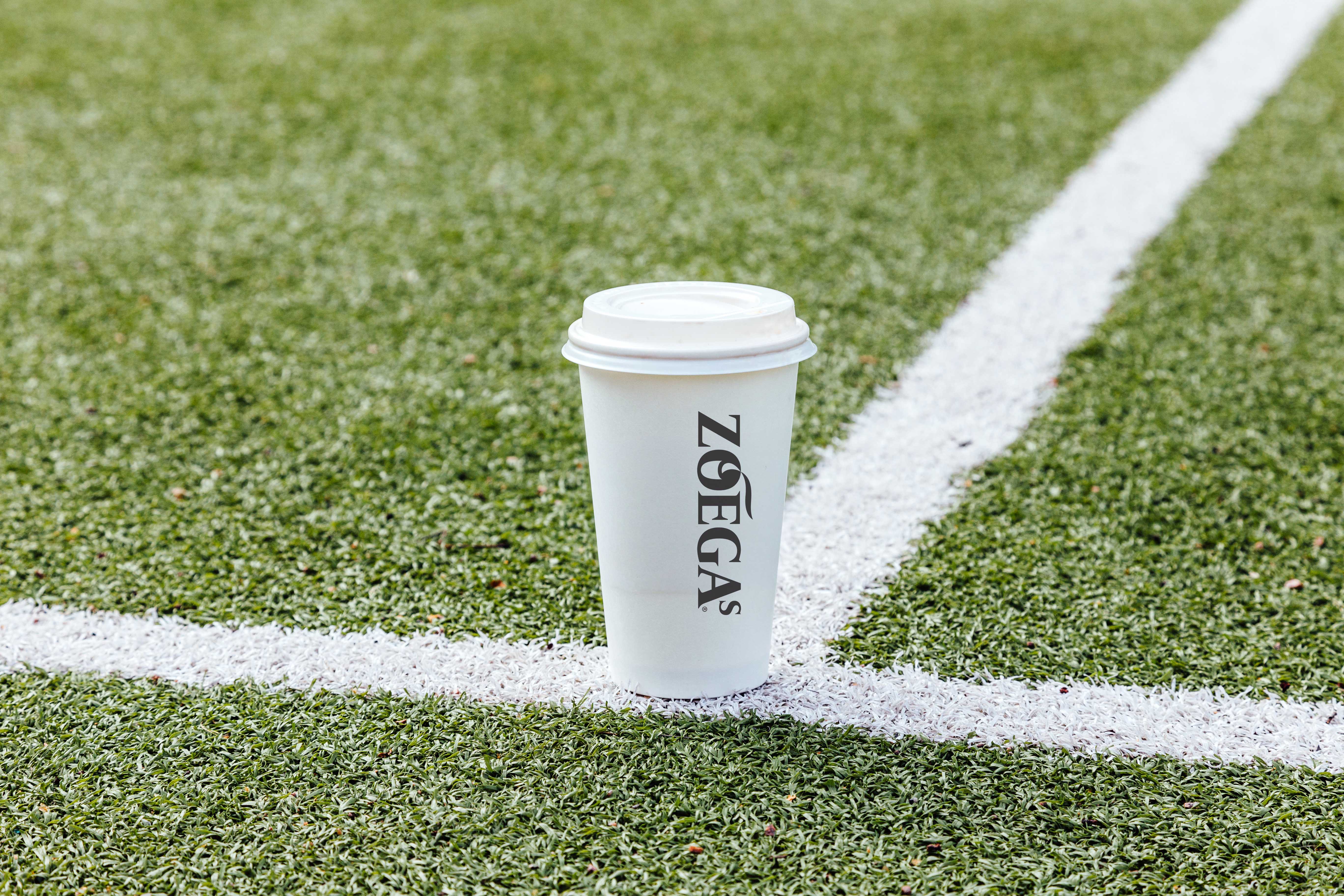 zoegas pappmugg i närbild på fotbollsplan