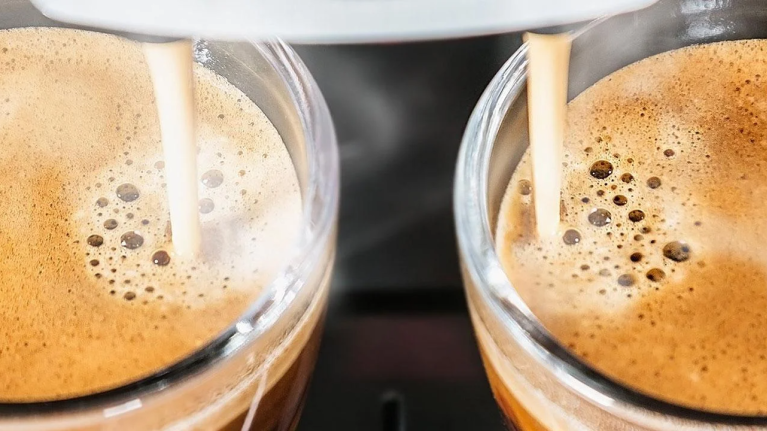 Två espresso rinner ner i koppar