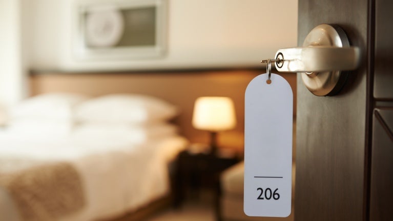Hotellrom med åpen dør og en kopp hengende med romnummeret 206