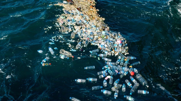 Hav med spridda fläckar av plastflaskor.