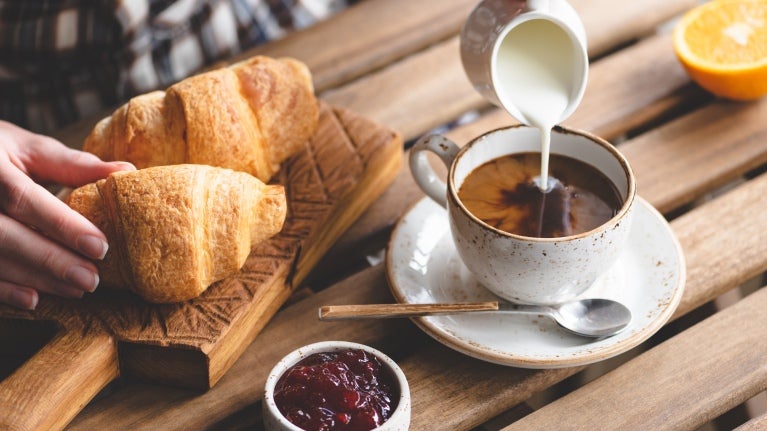 En tallerken croissanter og en kopp kaffe med melk