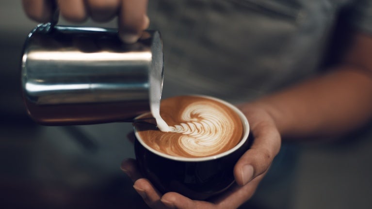 Cappuccino tarjoillaan kahvimukissa