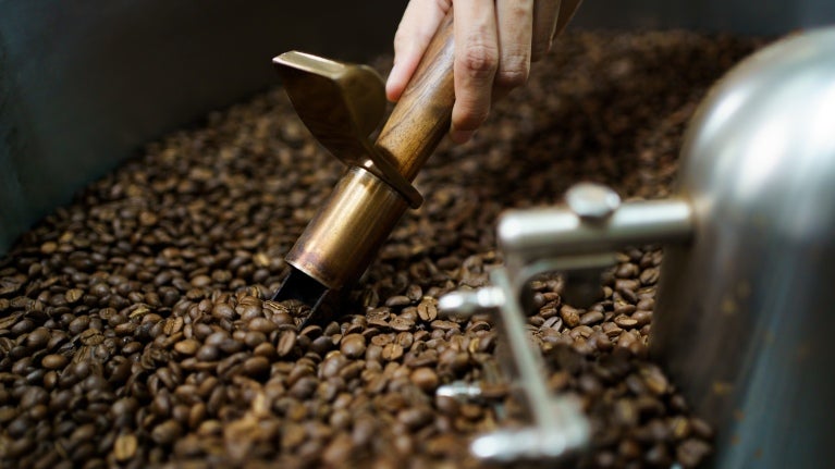 Nestké kaffebönor i en professionell malningsmaskin