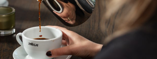 Man greppar en kopp Zoégas kaffe