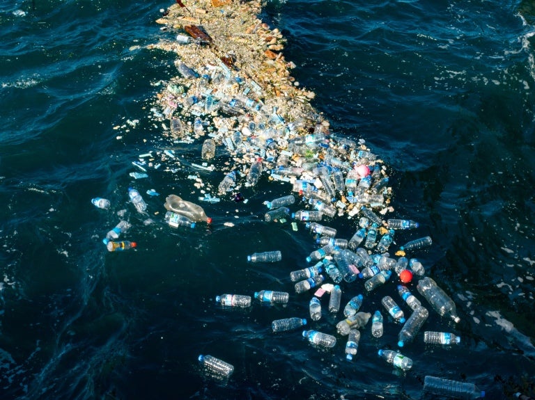 Hav med spridda fläckar av plastflaskor.