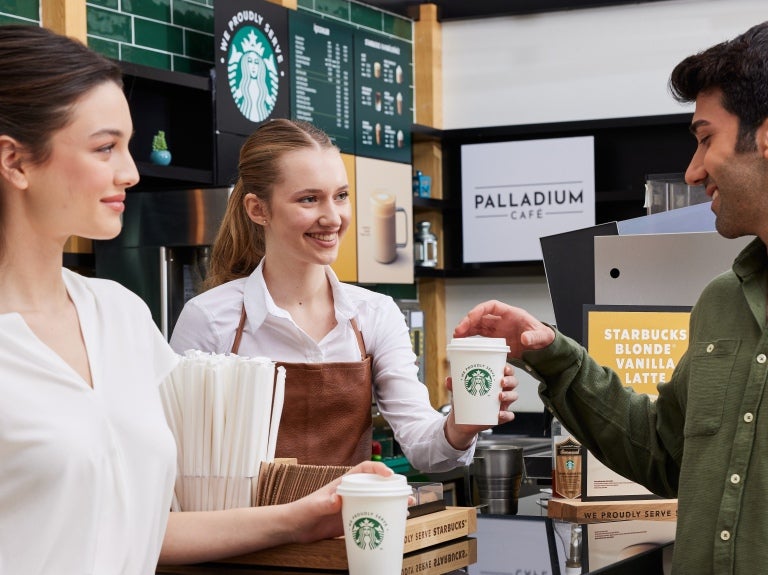 To gjester får servert kaffe på Starbucks