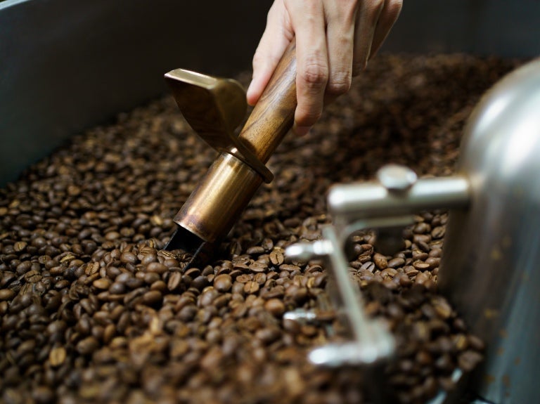 Nestké kaffebönor i en professionell malningsmaskin