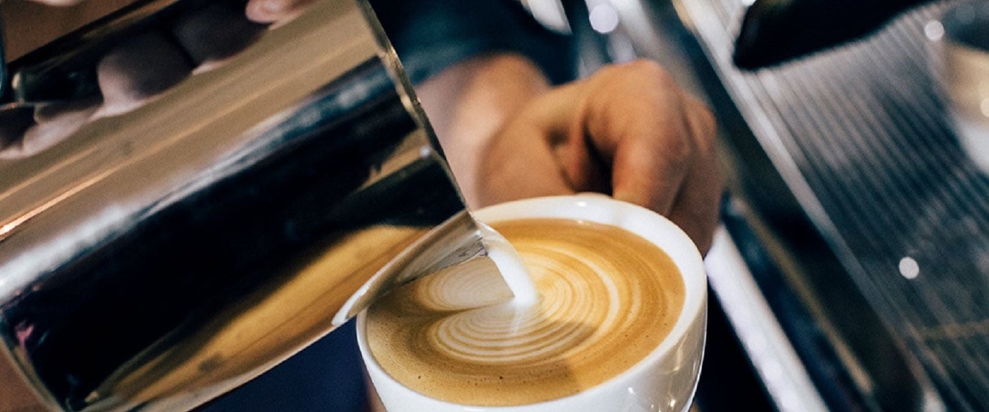 Kaffekopp med latteart som helles
