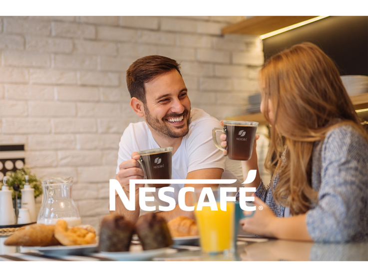 ett par dricker nescafé kaffe i ett café