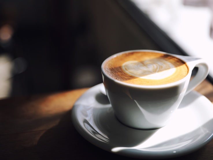 Cappuccino i en kopp med en hjärtformad design på toppen