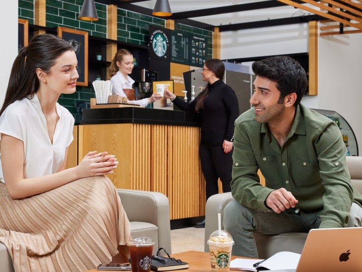 Kahvia Starbucksissa, muistikirjat ja kannettava tietokone pöydällä