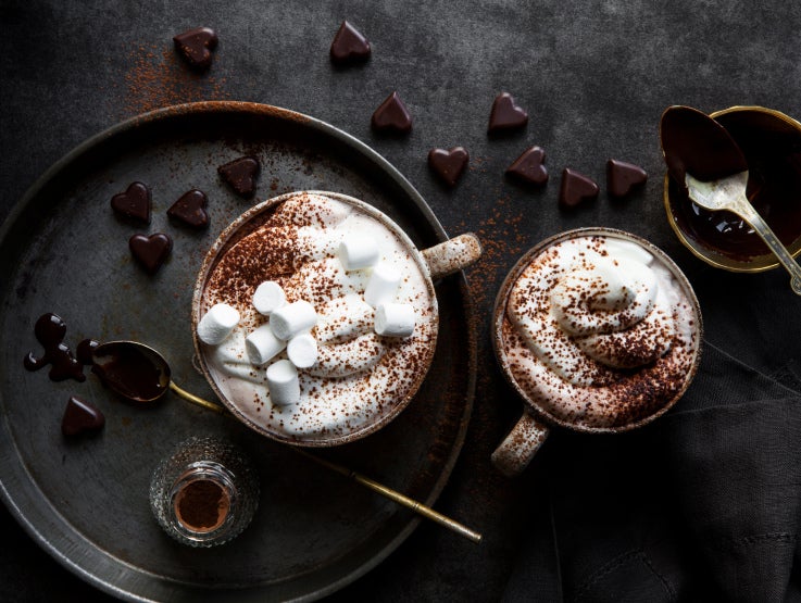 varm choklad i muggar med grädde och marshmallows