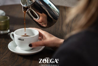 Servitris häller upp kaffe i Zoégas mugg
