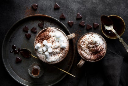 varm choklad i muggar med grädde och marshmallows