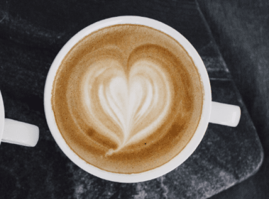 Cappuccinokopp sedd uppifrån med ett hjärta ritat i skummet