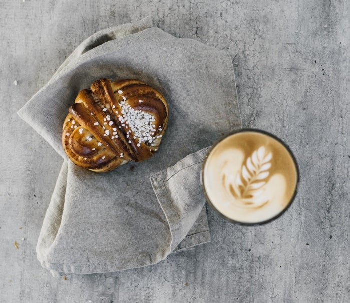 ett glas latte och en kanelsnäcka