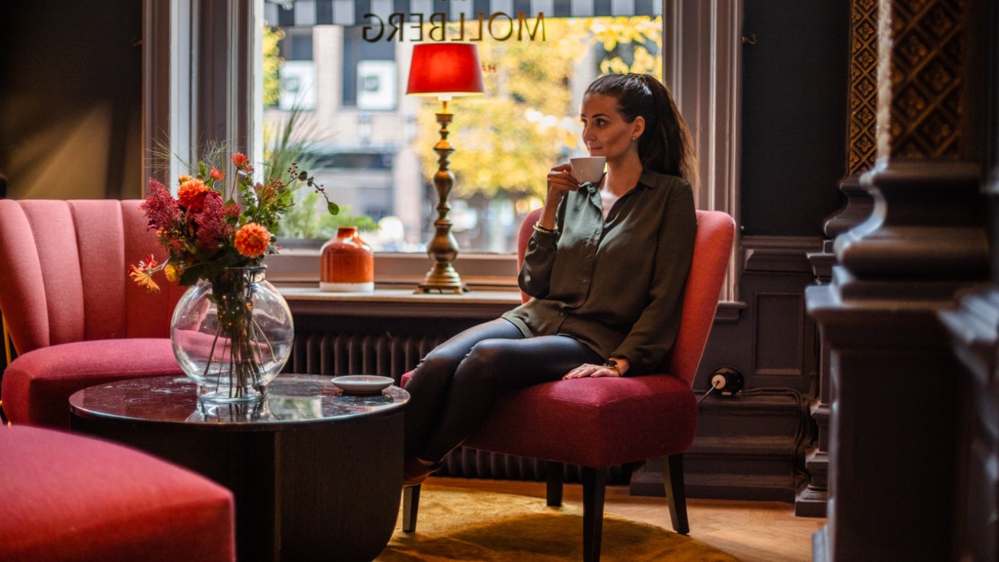 Kvinna dricker kaffe i hotellobby