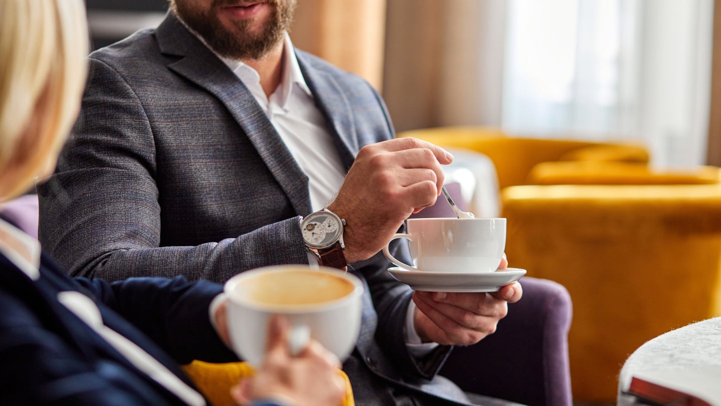 två personer dricker kaffe under konferens