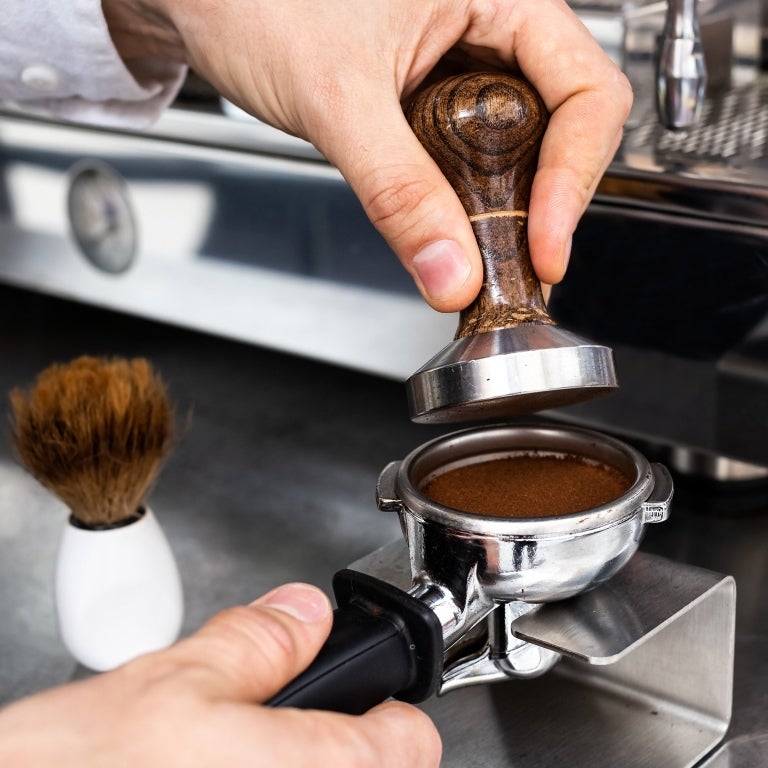 Barista tampar espresso i portafilter
