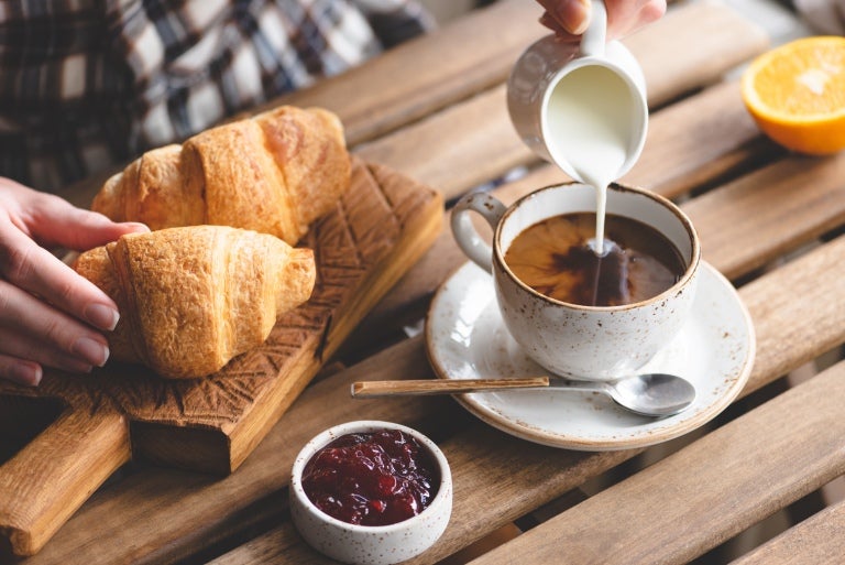 En tallerken croissanter og en kopp kaffe med melk